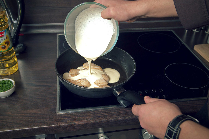 Chicken fillet on a frying pan in mayonnaise and garlic sauce
