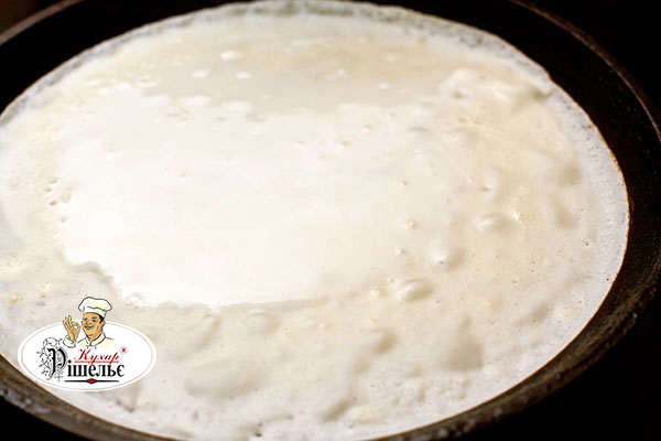 A thin pancake on a frying pan