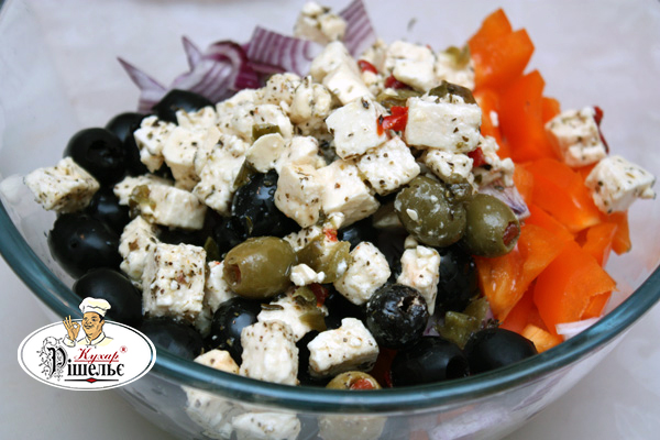 Sliced onion, paprika with Feta cheese and black olives in a bowl